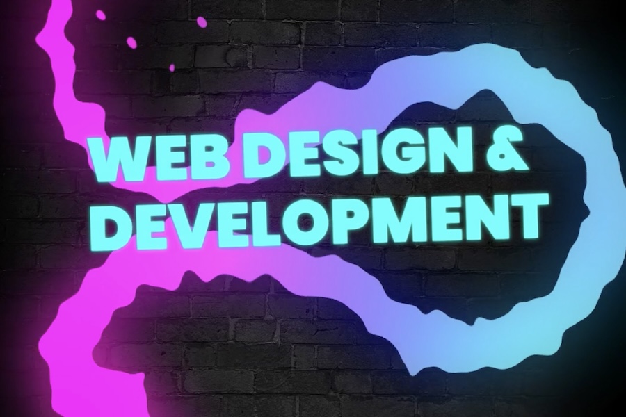 Brick wall background with neon elements on top. The text reads, "web design & development"